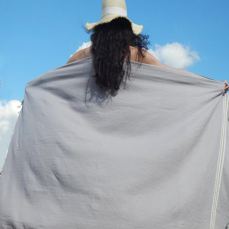 Woman holding oversized light grey Turkish beach towel