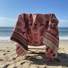 Pink blanket with fish pattern draped over a chair outdoors